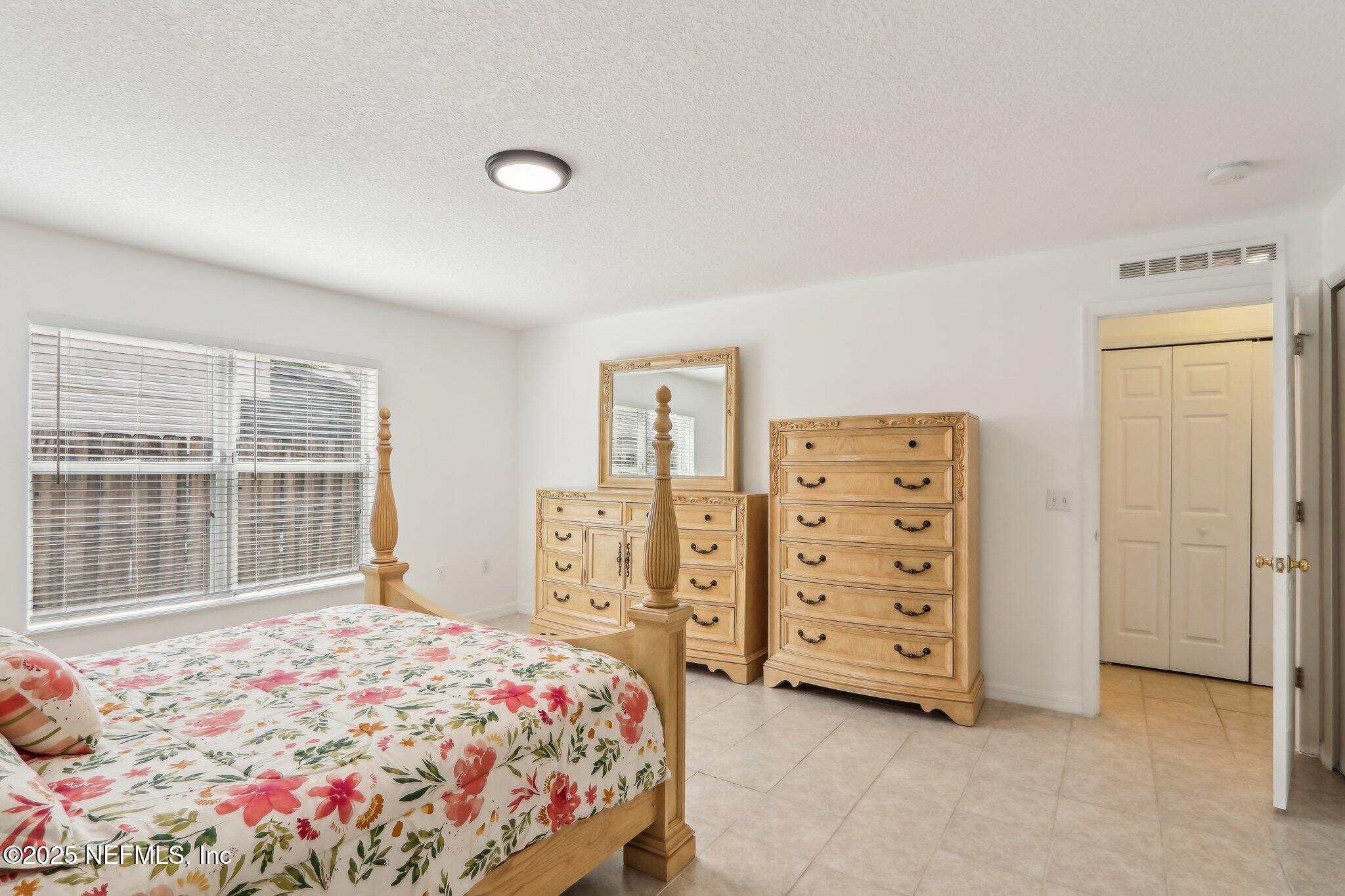 76391 Longleaf Loop Yulee, FL 32097 - Photo 18 of 58 a bedroom with a bed and a window