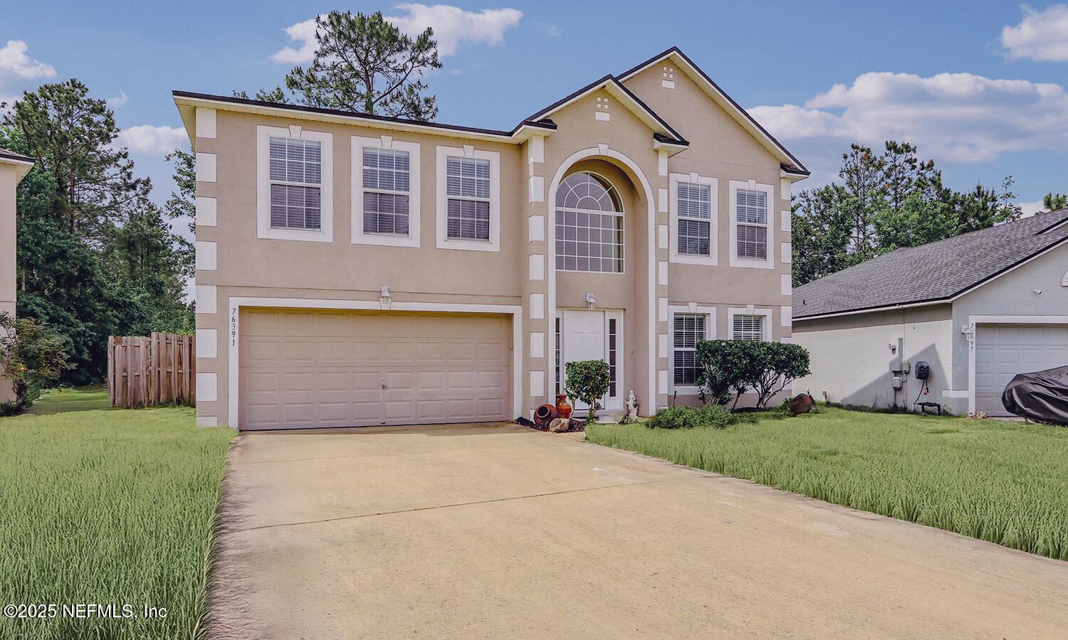 76391 Longleaf Loop Yulee, FL 32097 - Photo 2 of 58 a front view of a house with a yard and garage