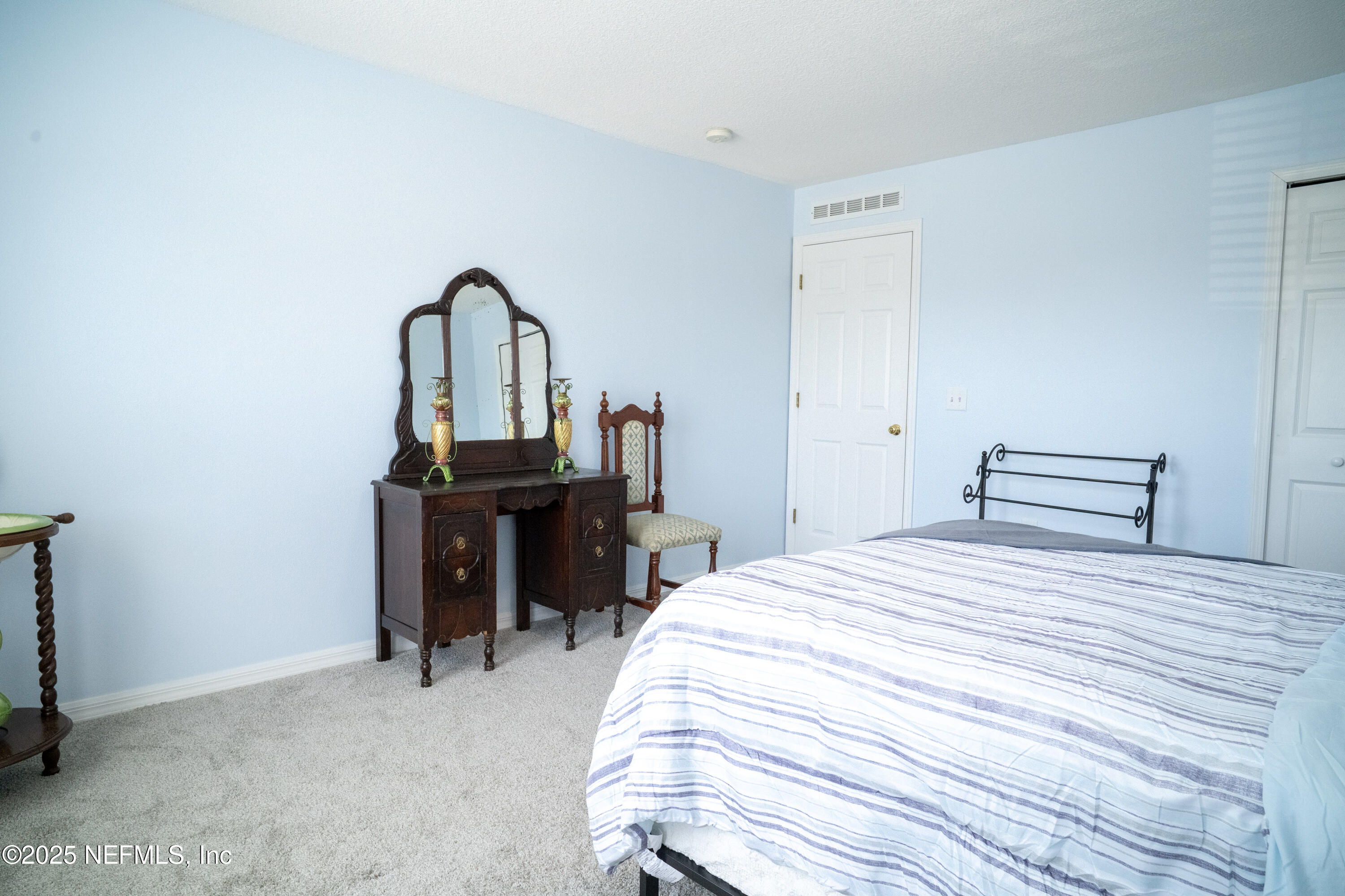76391 Longleaf Loop Yulee, FL 32097 - Photo 21 of 58 a bedroom with a bed and a table in it
