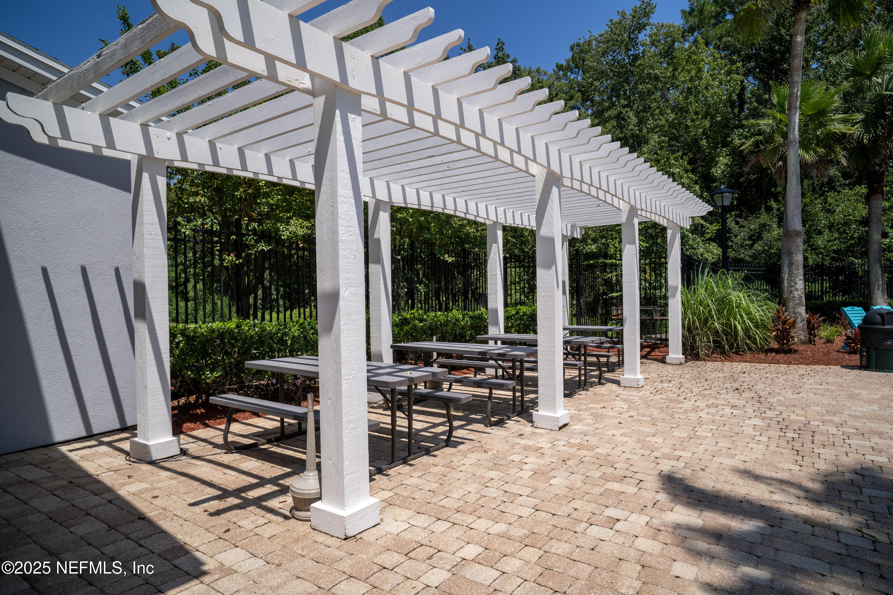 76391 Longleaf Loop Yulee, FL 32097 - Photo 53 of 58 a view of a patio with table and chairs under an umbrella next to a yard