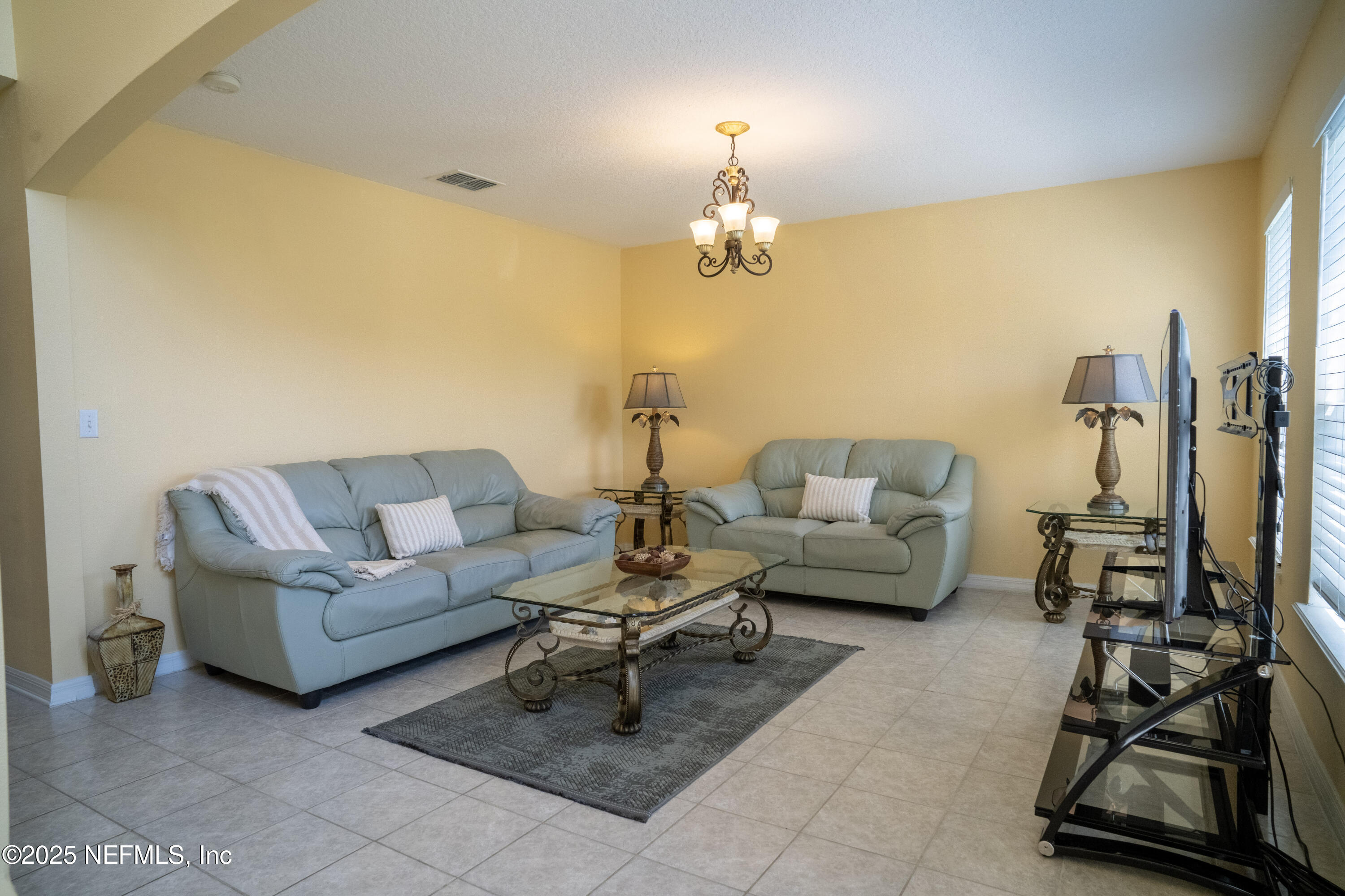 76391 Longleaf Loop Yulee, FL 32097 - Photo 6 of 58 a living room with furniture and a chandelier