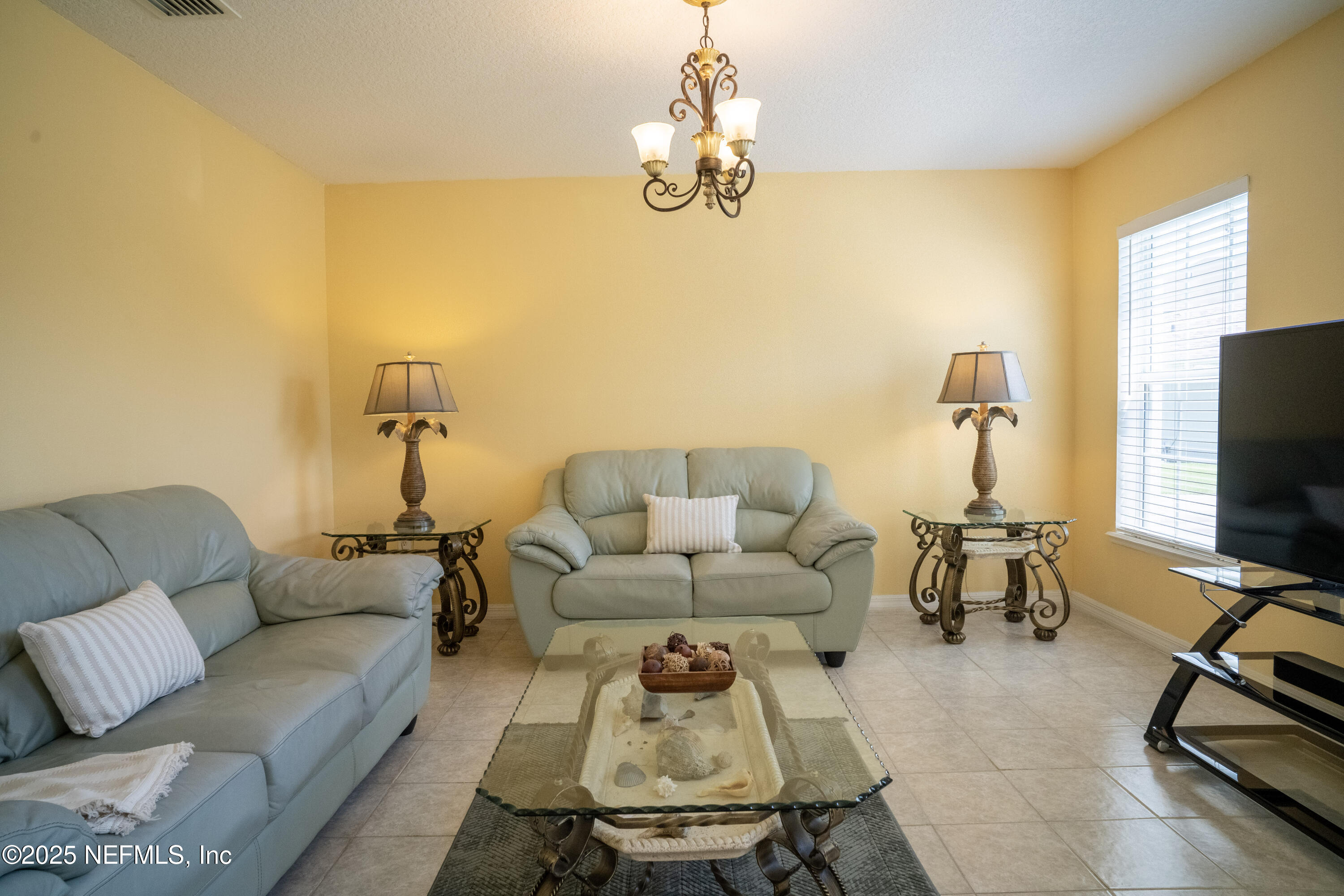 76391 Longleaf Loop Yulee, FL 32097 - Photo 8 of 58 a living room with furniture and a flat screen tv