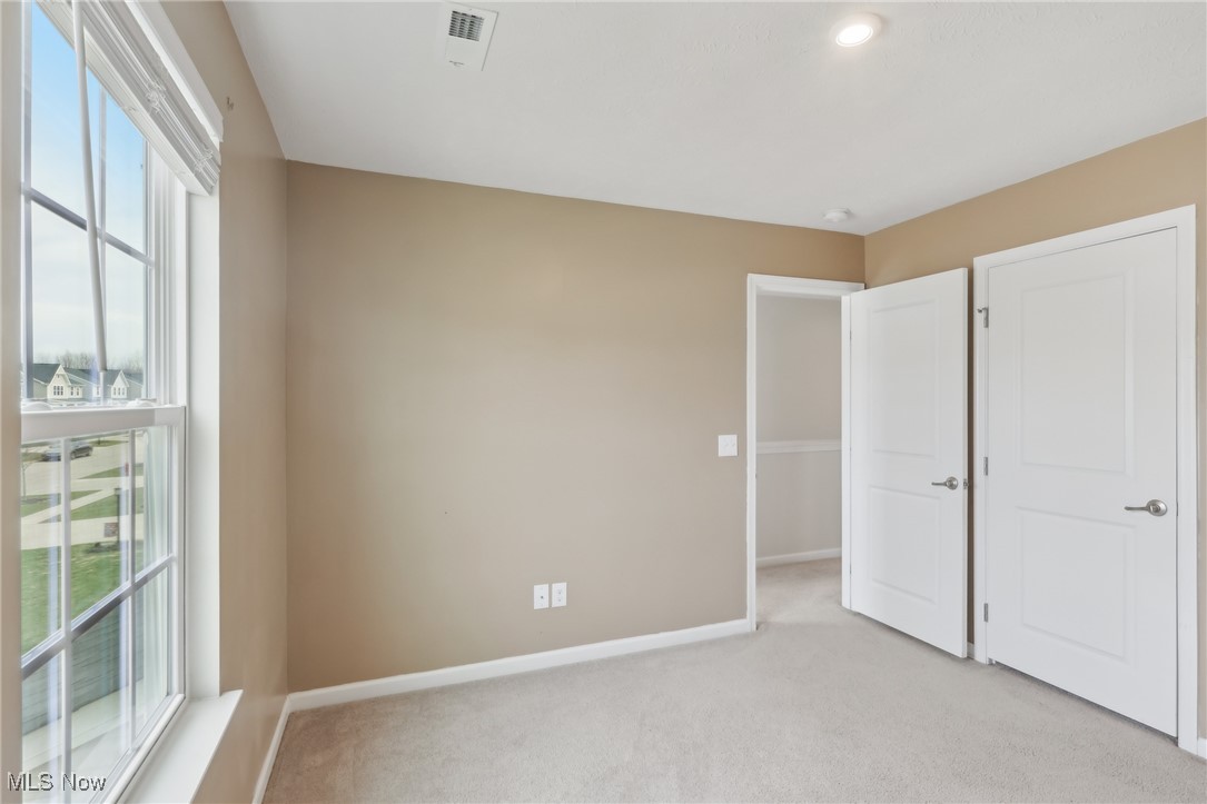 257 Stone Ridge Way Berea, OH 44017 - Photo 11 of 20 Unfurnished bedroom with light carpet, visible vents, multiple windows, and baseboards