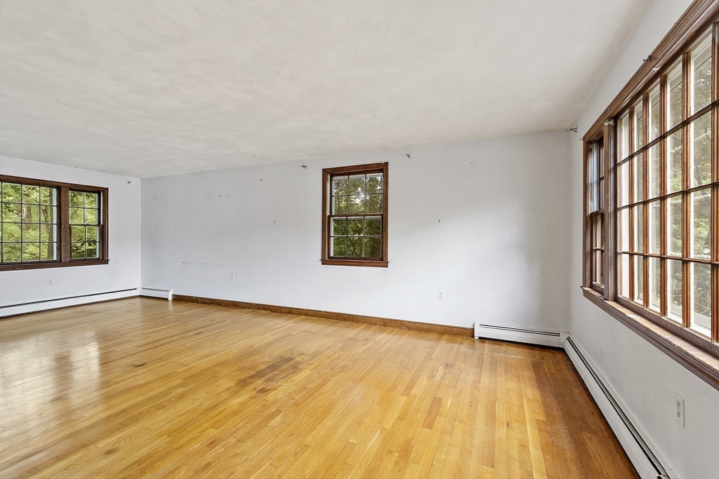 39 Winslow Street Concord, MA 01742 - Photo 11 of 22 an empty room with wooden floor and windows