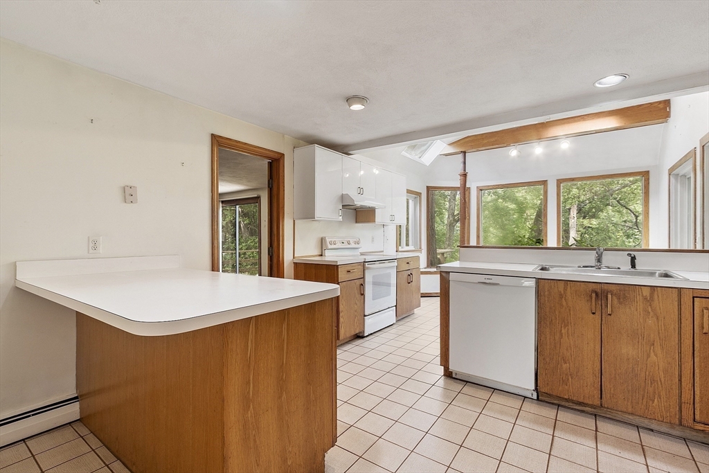 39 Winslow Street Concord, MA 01742 - Photo 3 of 22 a kitchen with kitchen island a sink a stove a refrigerator and white cabinets
