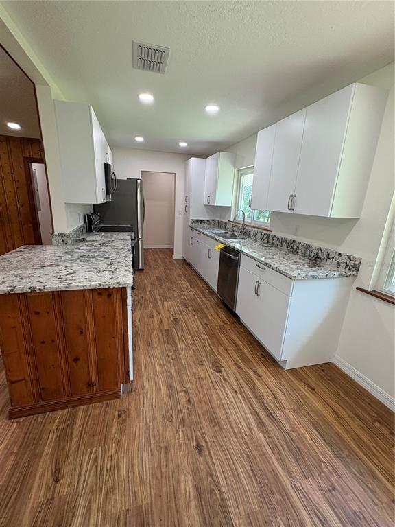 2110 Northwest 100th Street Ocala, FL 34475 - Photo 20 of 44 a large kitchen with stainless steel appliances granite countertop a lot of counter space and wooden floors