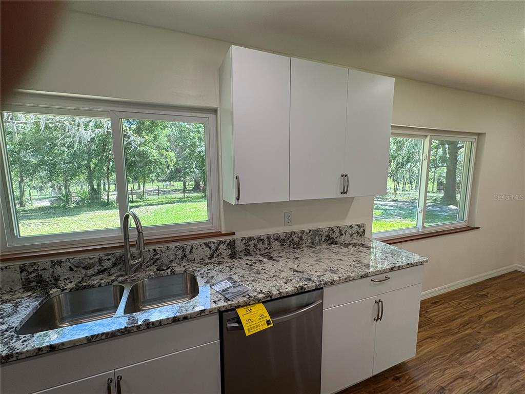 2110 Northwest 100th Street Ocala, FL 34475 - Photo 21 of 44 a kitchen with granite countertop a sink and a window