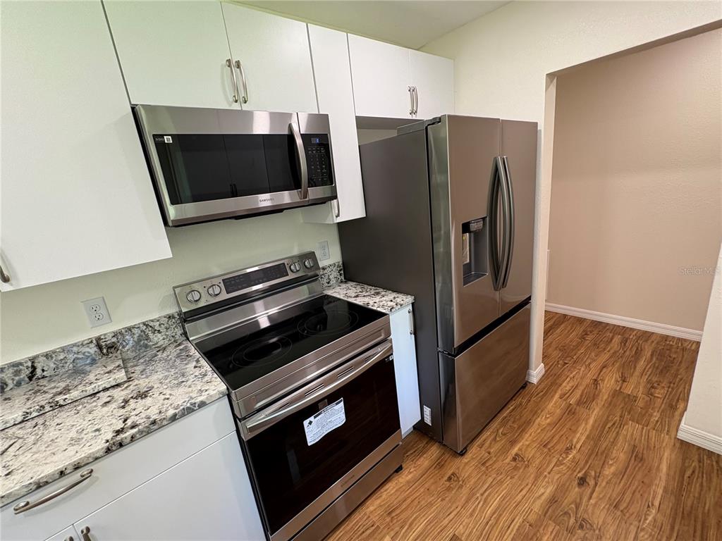 2110 Northwest 100th Street Ocala, FL 34475 - Photo 5 of 44 a kitchen with a stove microwave and refrigerator