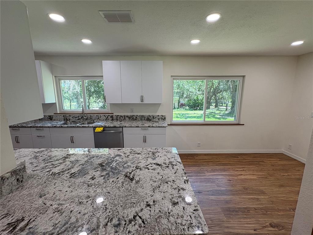 2110 Northwest 100th Street Ocala, FL 34475 - Photo 6 of 44 a kitchen with granite countertop a stove a sink and a window