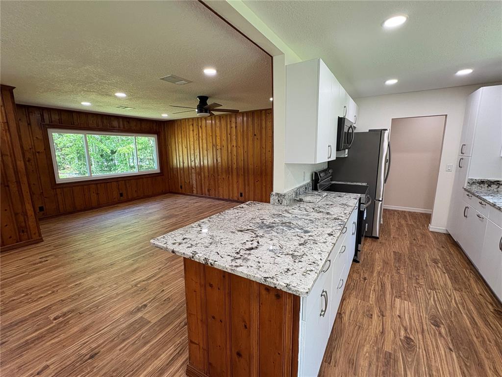 2110 Northwest 100th Street Ocala, FL 34475 - Photo 9 of 44 a view of kitchen island wooden floor furniture and a kitchen