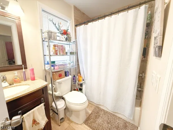 a bathroom with a sink a toilet and shower curtain
