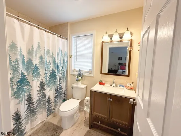 a bathroom with a sink a toilet and shower curtain