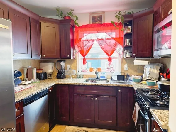 a kitchen with granite countertop a sink stove and cabinets