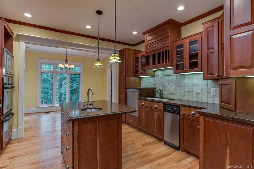 1322 Baber Road Rutherfordton, NC 28139 - Photo 7 of 24 a kitchen with stainless steel appliances granite countertop wooden cabinets a refrigerator a sink a stove and wooden floors