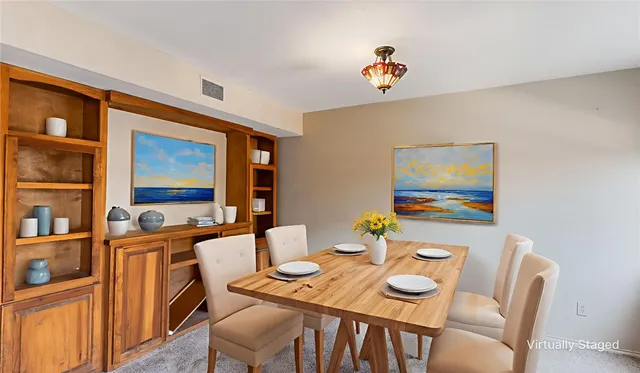 a view of a dining room with furniture a rug and wooden floor