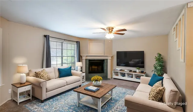 a living room with furniture a fireplace and a flat screen tv