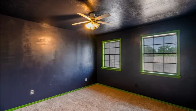 an empty room with fan and windows