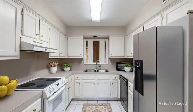 a kitchen with stainless steel appliances granite countertop a sink stove refrigerator and cabinets