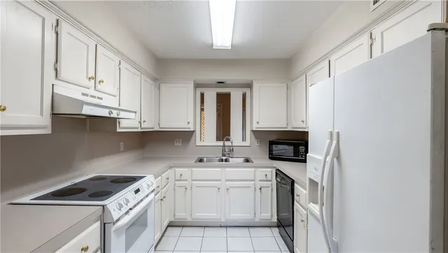 a kitchen with stainless steel appliances granite countertop a stove sink and cabinets