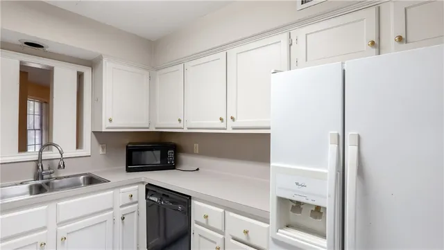 a kitchen with a sink and white cabinets