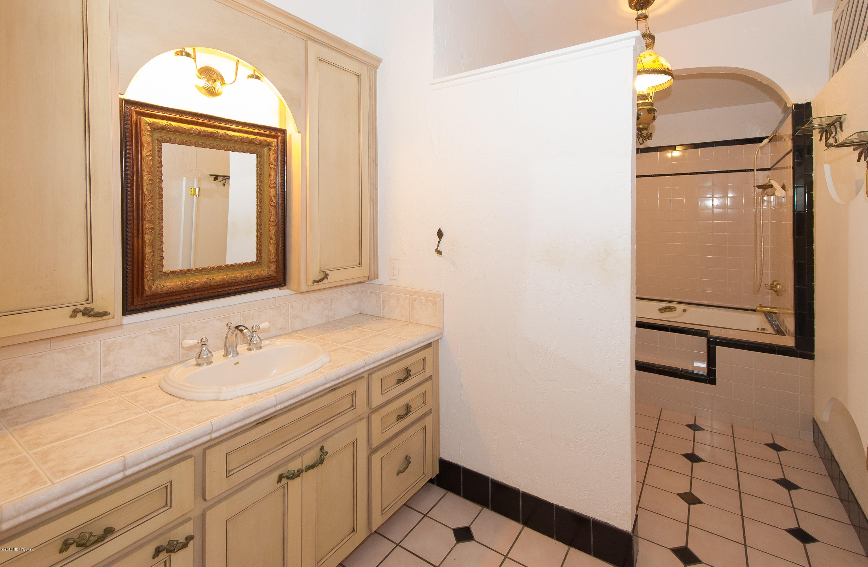 524 Vaill Point Road St. Augustine, FL 32086 - Photo 24 of 50 a bathroom with a sink a mirror and a shower