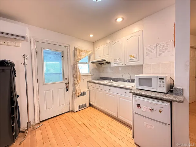 a kitchen with granite countertop white cabinets and white appliances