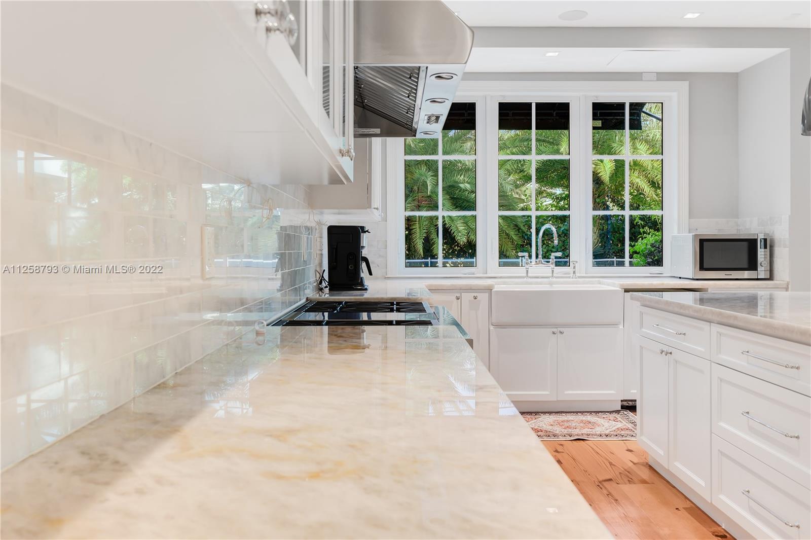 1311 Alhambra Circle Miami, FL 33134 - Photo 19 of 56 a kitchen with a sink a counter top space a large window and stainless steel appliances