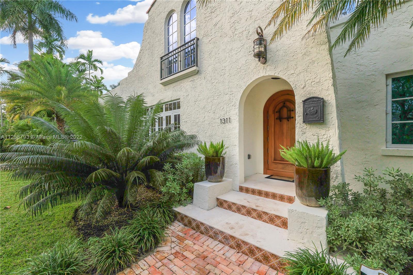 1311 Alhambra Circle Miami, FL 33134 - Photo 3 of 56 a front view of a house with a garden