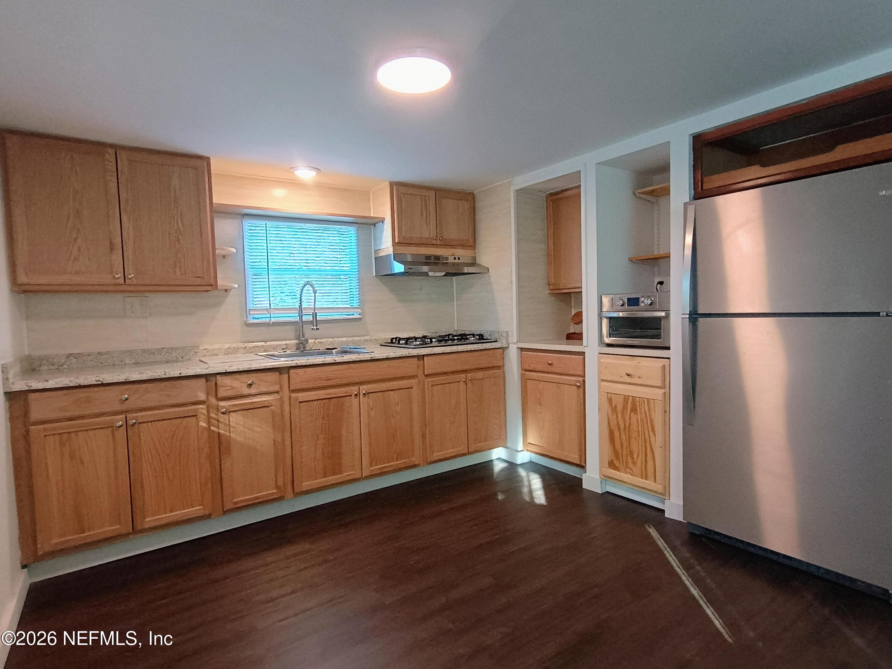 215 Pine Tree Trail Crescent City, FL 32112 - Photo 18 of 25 a kitchen with granite countertop stainless steel appliances a refrigerator and a sink