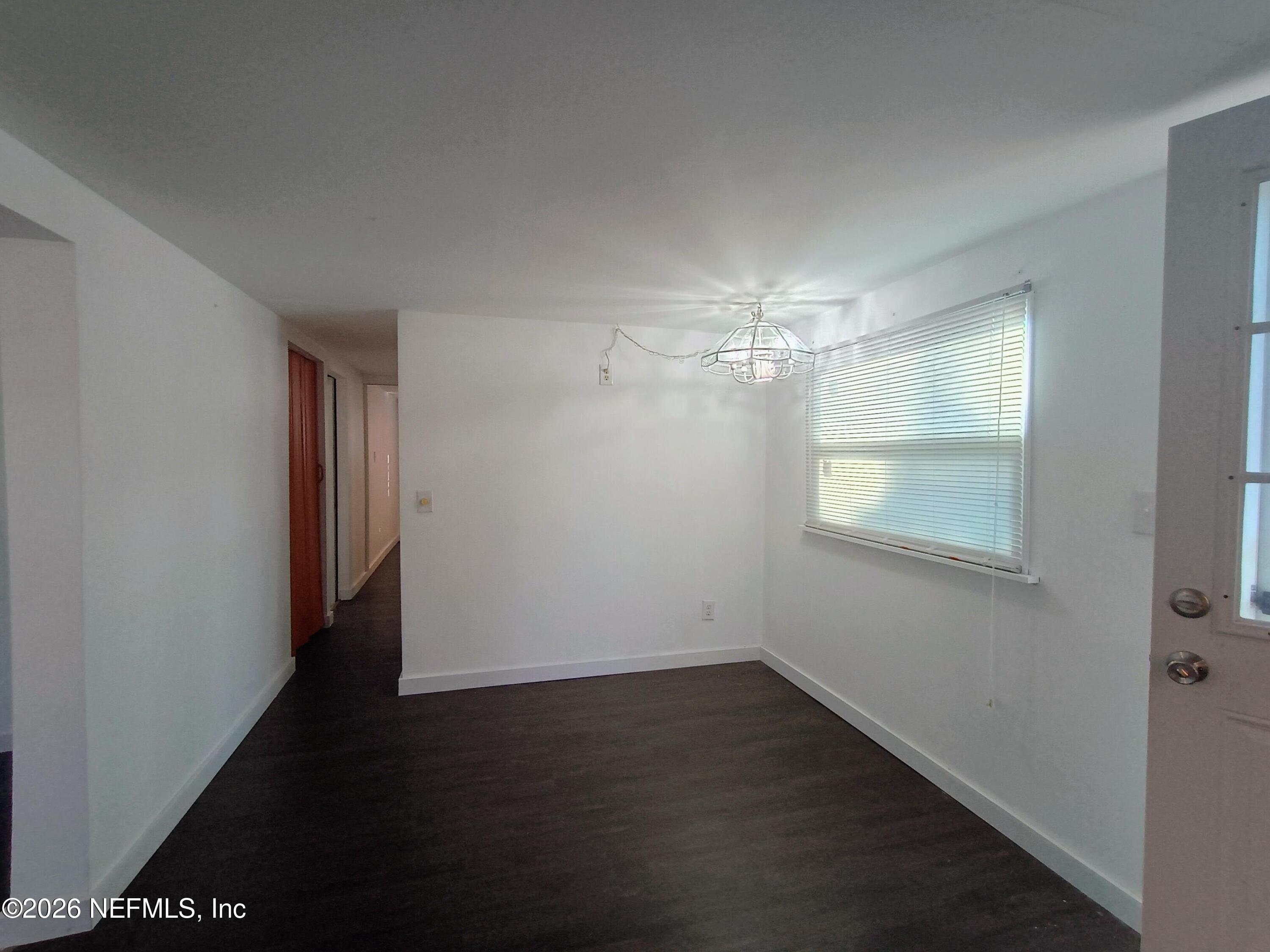 215 Pine Tree Trail Crescent City, FL 32112 - Photo 8 of 25 an empty room with wooden floor and windows