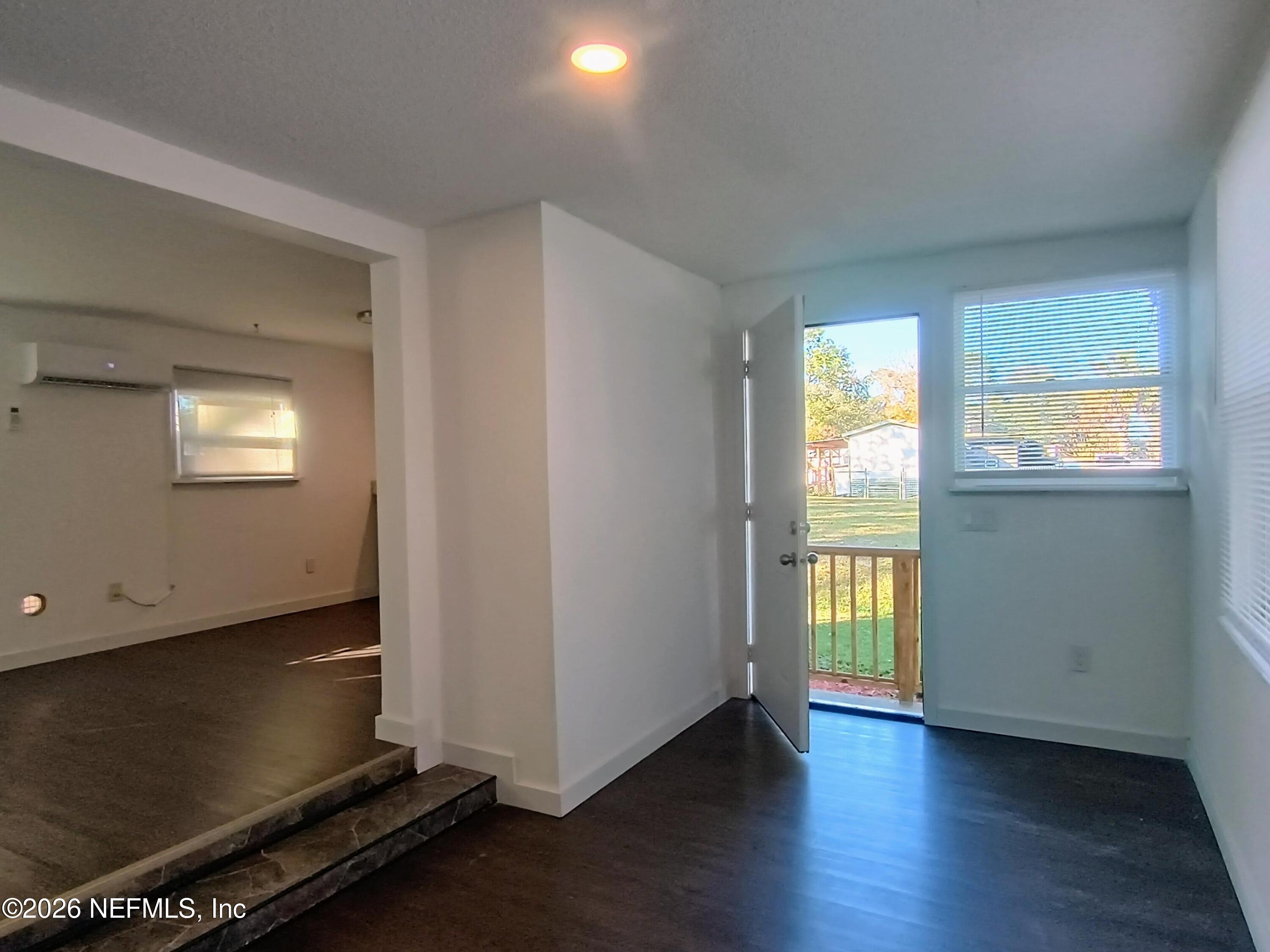 215 Pine Tree Trail Crescent City, FL 32112 - Photo 9 of 25 an empty room with wooden floor and windows