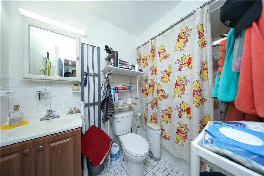 5813 4th Avenue Brooklyn, NY 11220 - Photo 11 of 25 a bathroom with a sink toilet and shower curtain