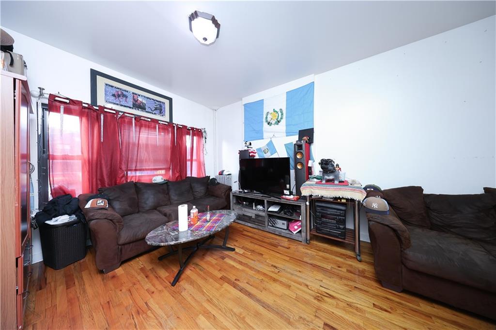 5813 4th Avenue Brooklyn, NY 11220 - Photo 4 of 25 a living room with furniture and a flat screen tv