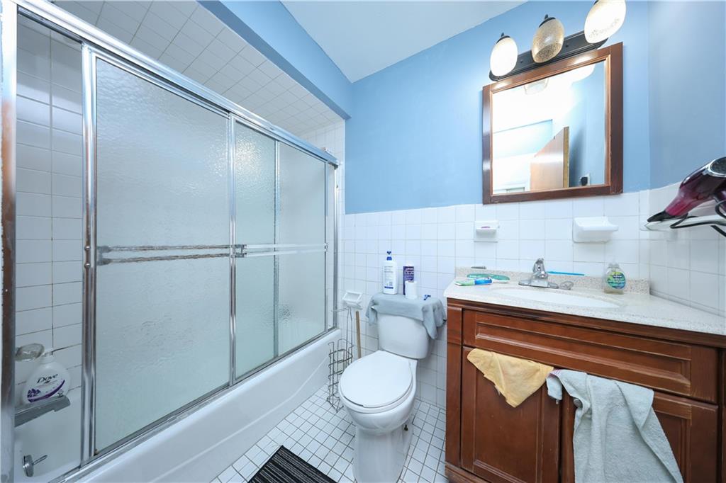 5813 4th Avenue Brooklyn, NY 11220 - Photo 10 of 25 a bathroom with a toilet a sink and mirror