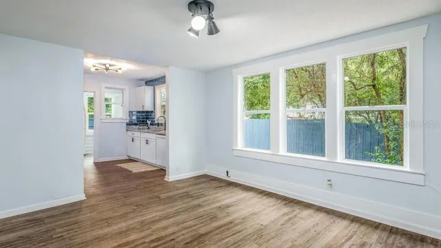 a view of a kitchen and an empty room with a window