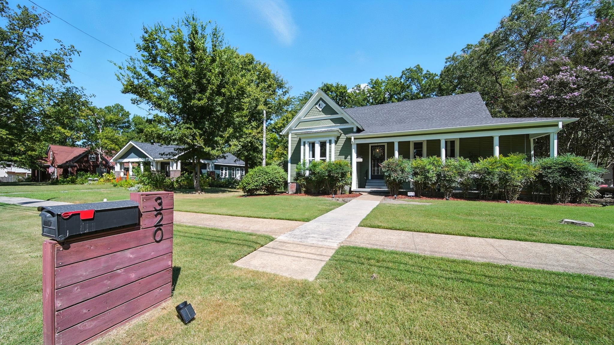 320 North Maple Street Covington, TN 38019 - Photo 1 of 35 View of front facade with a front yard, a porch, and a shingled roof