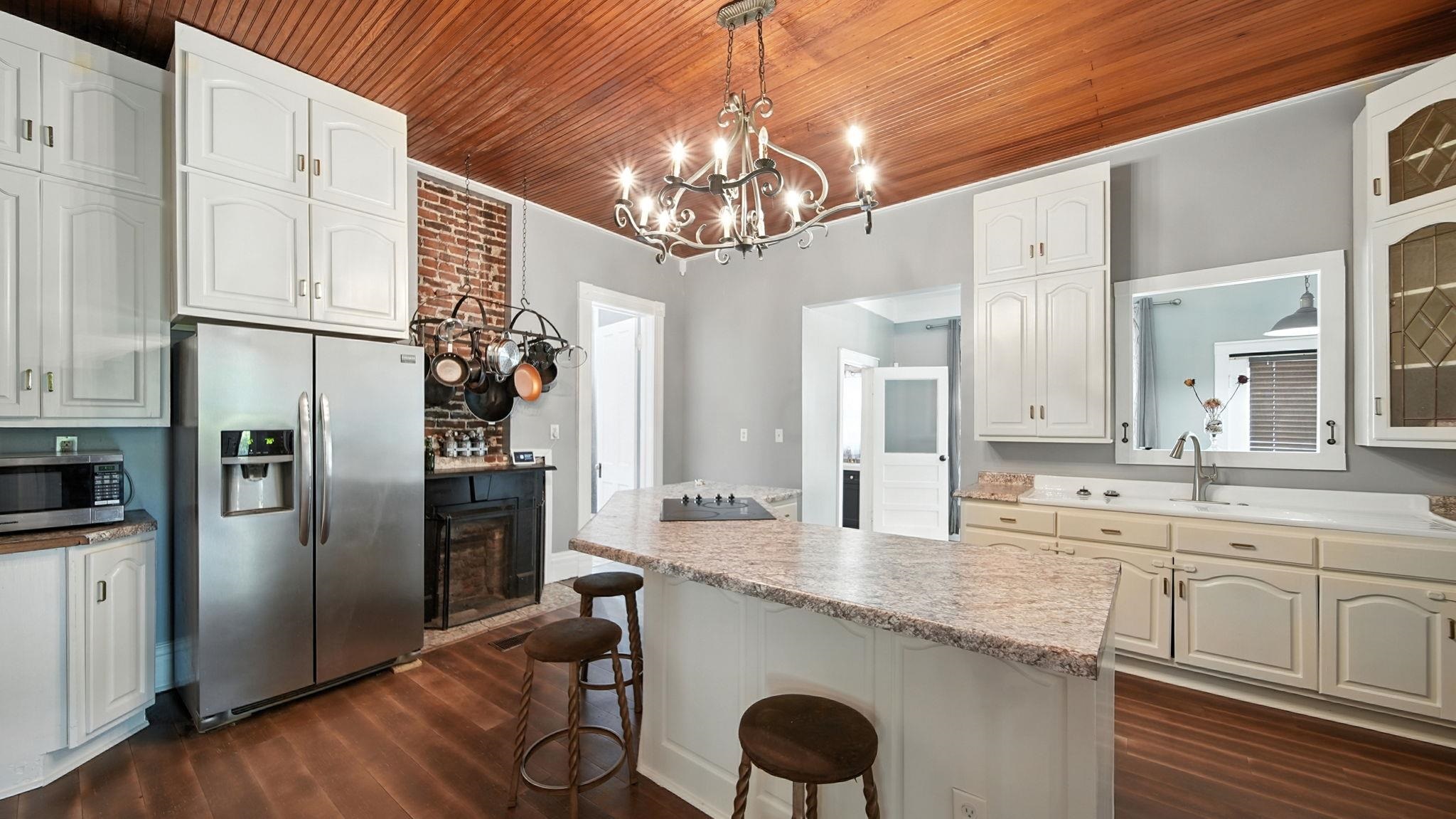 320 North Maple Street Covington, TN 38019 - Photo 12 of 35 Kitchen featuring stainless steel appliances, a kitchen island, pendant lighting, dark wood finished floors, and wood ceiling