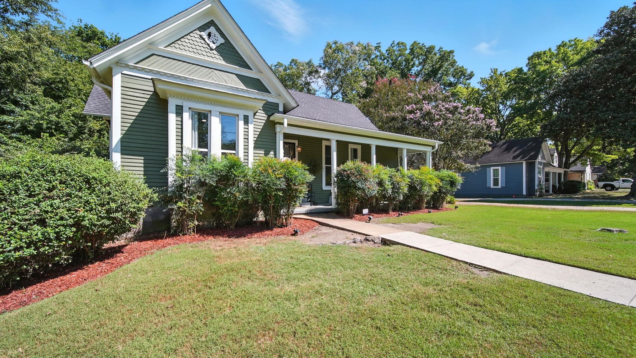 320 North Maple Street Covington, TN 38019 - Photo 2 of 35 Victorian-style house with a front yard, a porch, and a shingled roof