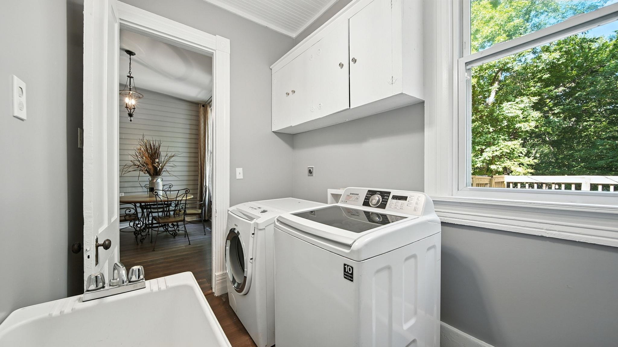 320 North Maple Street Covington, TN 38019 - Photo 21 of 35 Washroom featuring dark wood-style floors, cabinet space, healthy amount of natural light, and washing machine and clothes dryer
