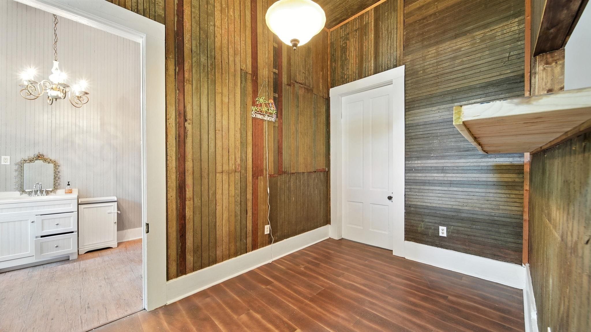 320 North Maple Street Covington, TN 38019 - Photo 28 of 35 Interior space with dark wood-style floors, wooden walls, and a chandelier