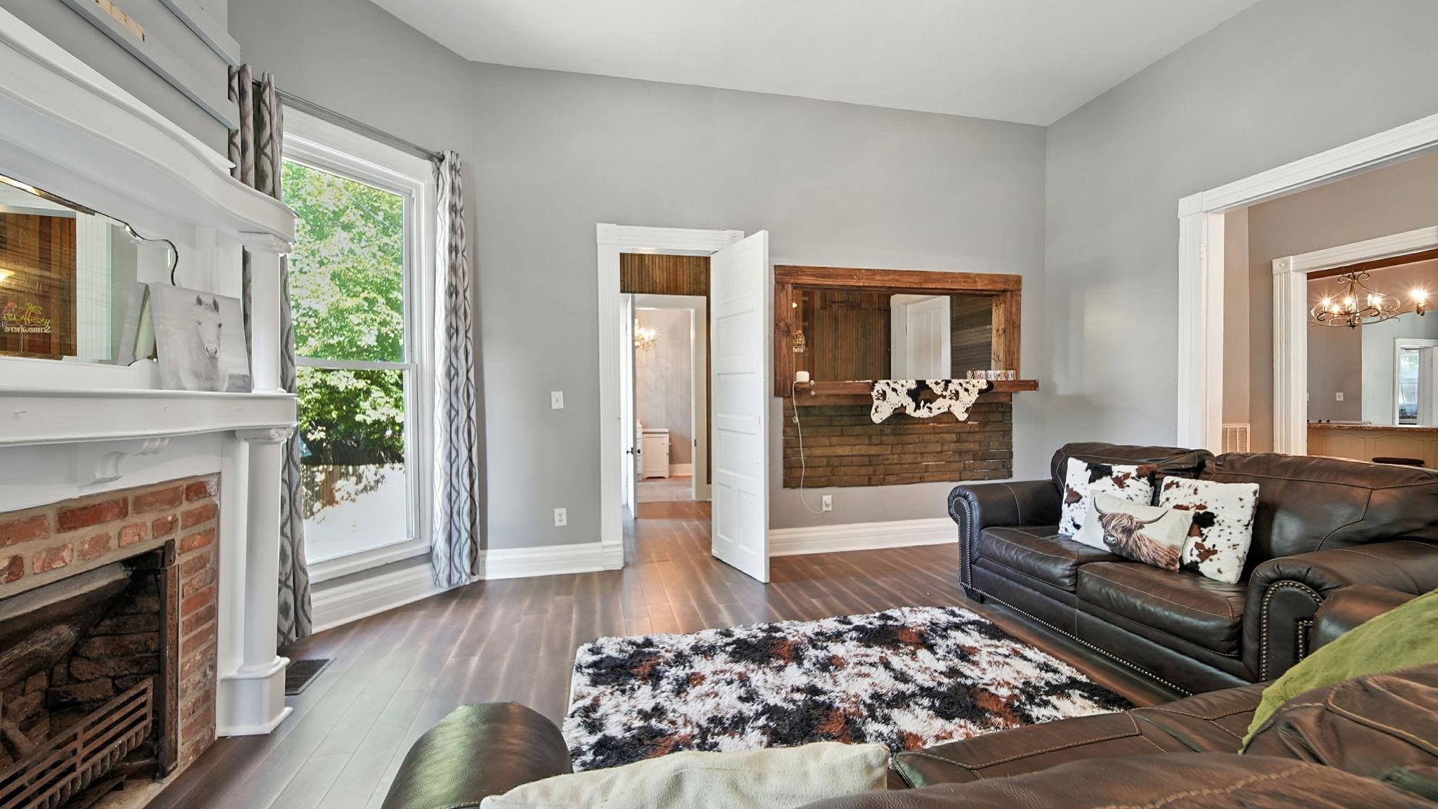320 North Maple Street Covington, TN 38019 - Photo 31 of 35 Living room featuring a chandelier, dark wood finished floors, and a fireplace