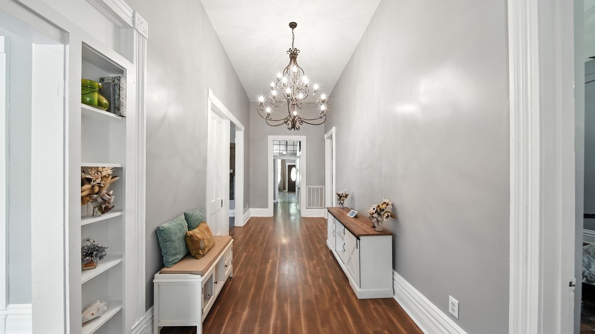 320 North Maple Street Covington, TN 38019 - Photo 6 of 35 Hallway with dark wood-style floors, a chandelier, and built in shelves