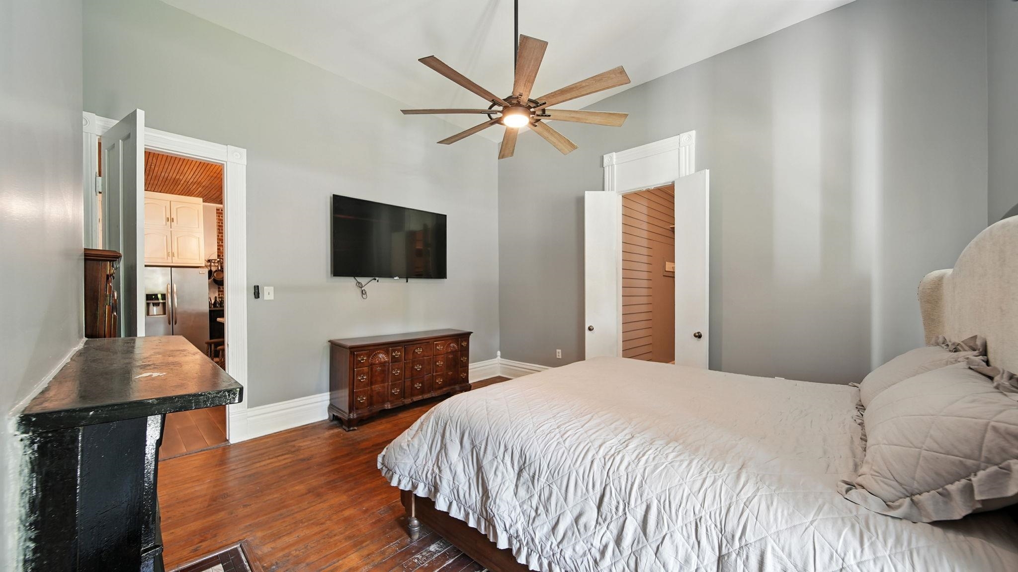 320 North Maple Street Covington, TN 38019 - Photo 9 of 35 Bedroom featuring dark wood-style floors, stainless steel fridge, a ceiling fan, and a high ceiling
