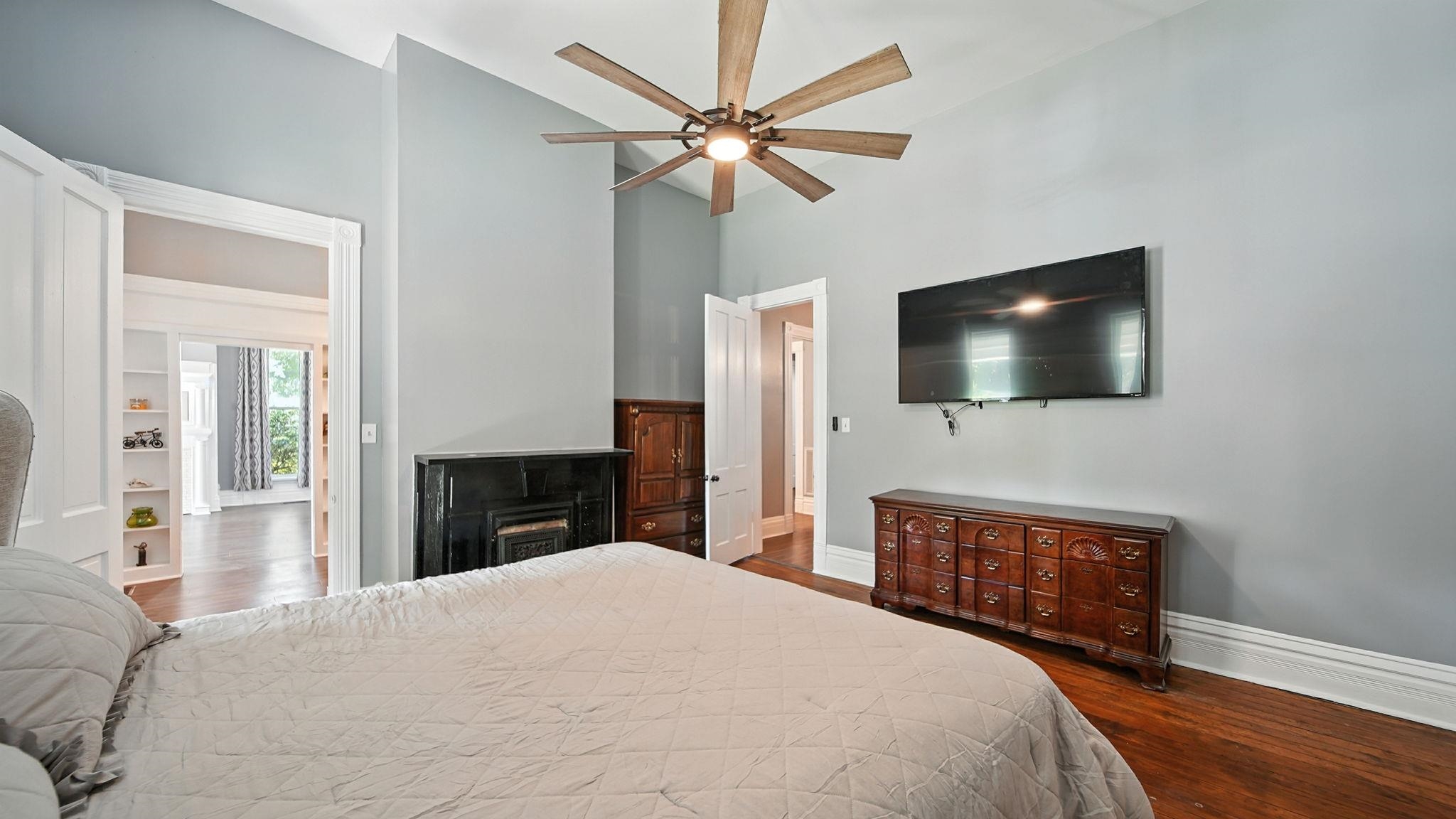 320 North Maple Street Covington, TN 38019 - Photo 10 of 35 Bedroom with a towering ceiling, dark wood-style flooring, a ceiling fan, and a fireplace