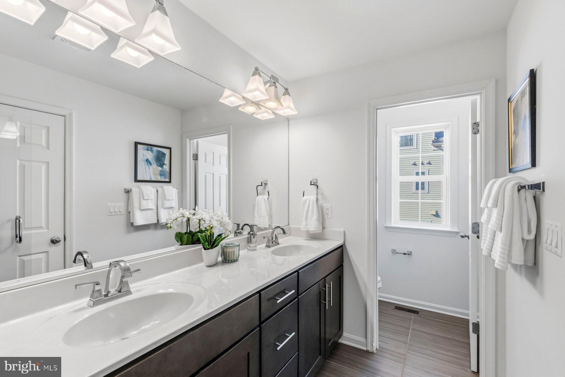 7205 Barry Lane Elkridge, MD 21075 - Photo 14 of 22 a bathroom with a double vanity sink a mirror and a shower