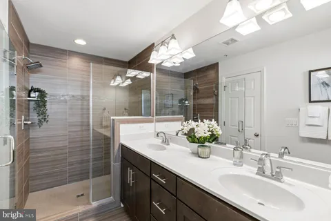 a bathroom with a double vanity sink mirror and shower