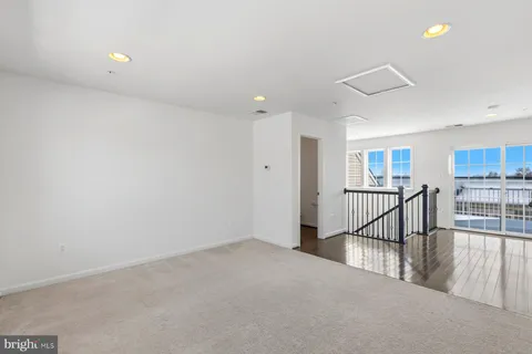 a view of a hallway with wooden floor and windows
