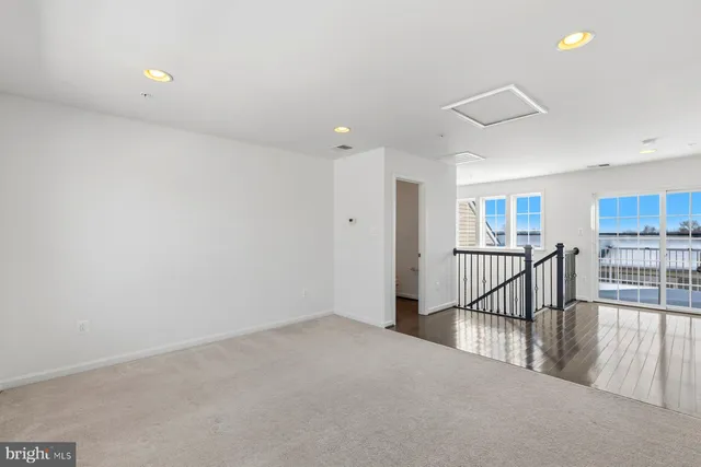 a view of a hallway with wooden floor and windows