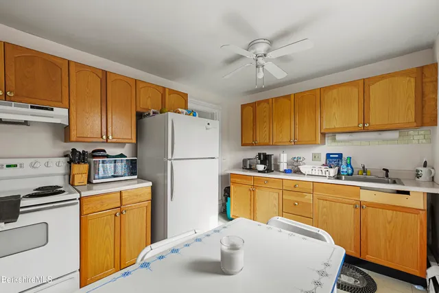 a kitchen with sink a refrigerator and cabinets