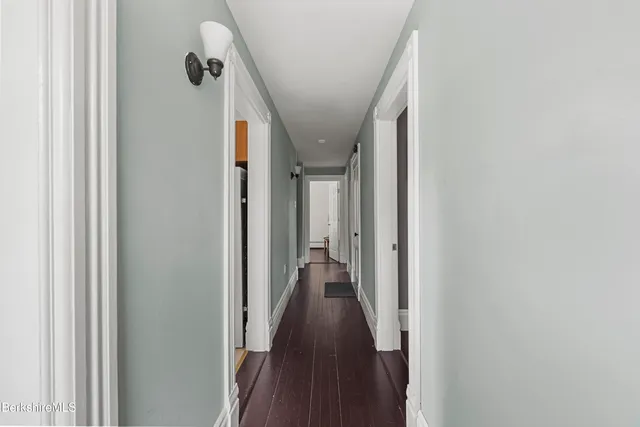 a view of a hallway with wooden floor and staircase